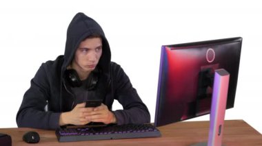 Başlıklı hacker beyaz arka planda dizüstü bilgisayar ve akıllı telefon kullanıyor.