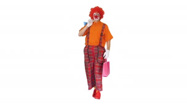 Śmieszny klaun spacerujący z torbami na białym tle. — Wideo stockowe