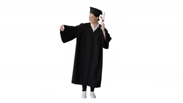 Feliz graduada sosteniendo diploma y haciendo selfie en su teléfono sobre fondo blanco. — Vídeos de Stock