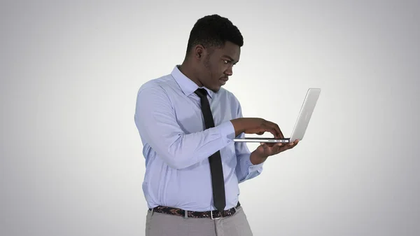 Afro American business man working with laptop on gradient backg