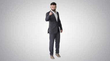 Sakallı bir iş adamı el kol hareketleri gösteriyor. Parmak yukarı, arka plan yukarı doğru..