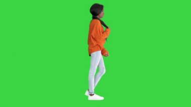 Parlak süveter ve kot pantolon giymiş gülümseyen Afrikalı Amerikalı kadın elleri yeşil ekranda, Chroma Key.