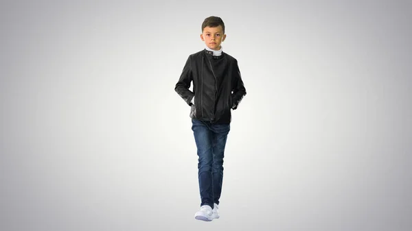 Niño en una chaqueta de cuero caminando con las manos en la media caña — Foto de Stock