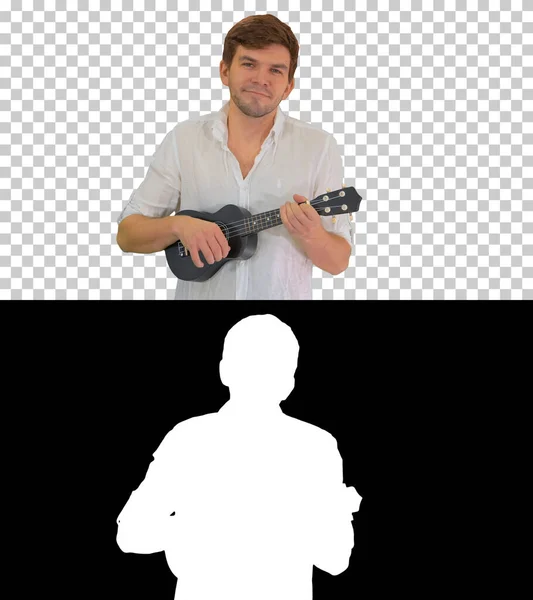 Souriant jeune homme jouant ukulele regardant dans la caméra, Alpha — Photo