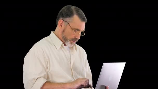 Opgewonden senior zakenman werkt aan een laptop, Alpha Channel — Stockvideo