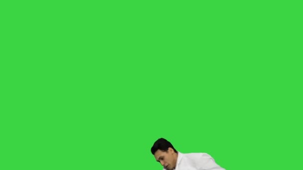 Fiatal férfi orvos táncos breakdance, állítsa be a köntös nézi a kamera, majd elsétál egy zöld képernyőn, Chroma Key. — Stock videók