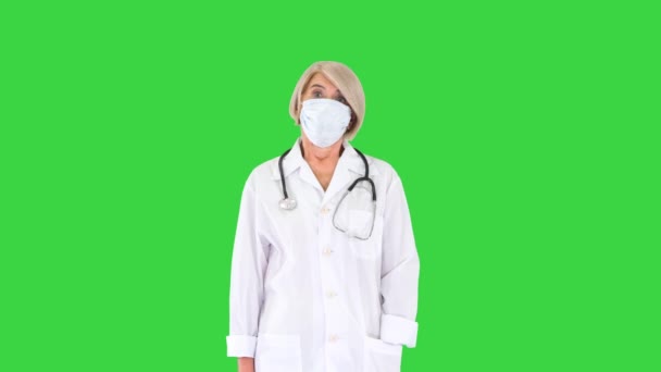 Médecin principale pendant une pandémie de coronavirus covid-19 enlève le masque de protection sur un écran vert, Chroma Key. — Video