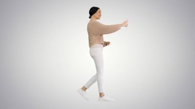 Gülümseyen ve el kol hareketi yapan genç bir kadın telefonunda video görüşmesi yapıyor.