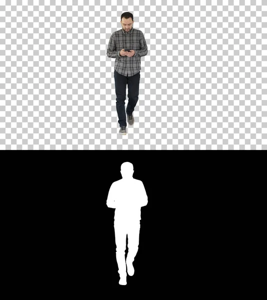 Młody człowiek spacerujący i korzystający z telefonu, wiadomości, Alpha Channel — Zdjęcie stockowe