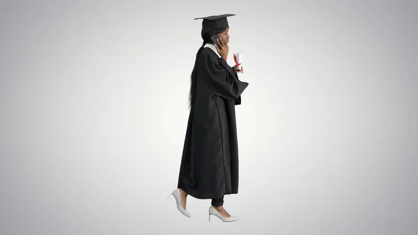 Afro-americano feminino estudante no graduação robe falando no th — Fotografia de Stock