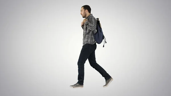 Молодой студент идет по стене зеленый фон с сумкой и — стоковое фото