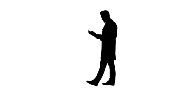 Silhouette Konzentrierter Arzt liest Dokumentation beim Gehen. — Stockfoto