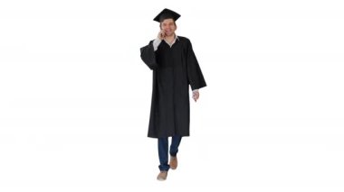 Beyaz arka planda diplomasıyla yürürken telefonda konuşan cüppe ve havan topu giymiş bir erkek mezun..
