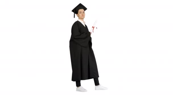 Female student in graduation robe holding diploma and waiving it around on white background. — Stock Video