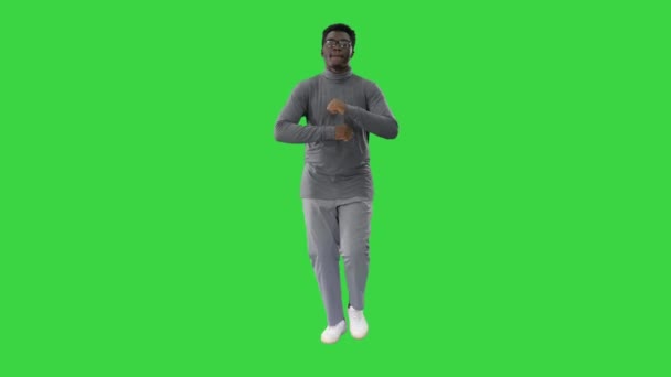 Junger afrikanisch-amerikanischer Mann in grauer Kleidung und Brille beim Gehen auf einem Green Screen, Chroma Key. — Stockvideo