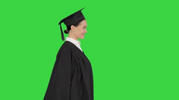 Mezuniyet cüppeli gülümseyen bayan öğrenci yeşil ekranda diplomasıyla yürüyor, Chroma Key.. — Stok video