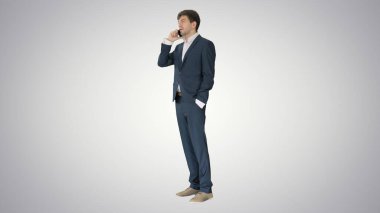 Yakışıklı genç işadamı telefonda gradyan sırtından konuşuyor.