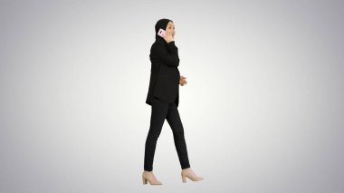 Çekici, modern Müslüman kadın cep telefonuyla konuşuyor.