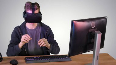 Oyuncu çocuk gradyan arka planda VR kulaklıkla oynuyor.