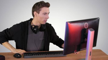 Sinirli adam gradyan ba 'da bilgisayar başında video oyunları izliyor.