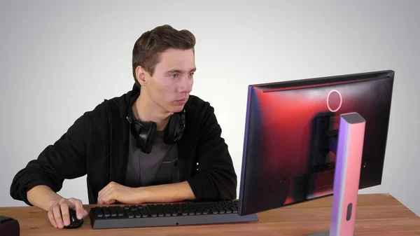 Young man gamer watching stream game on gradient background. — Stock Photo, Image
