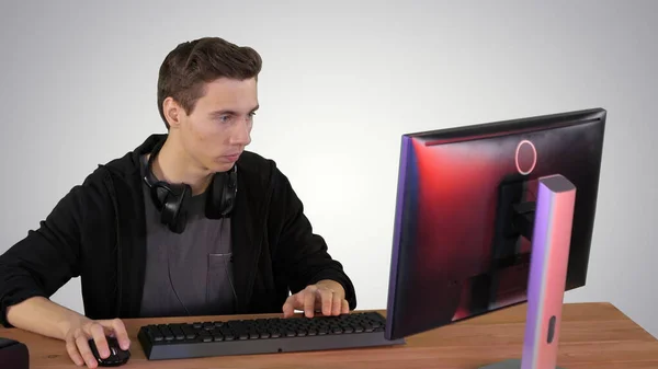 Gamer playing a video game on personal computer on gradient back — Stock Photo, Image