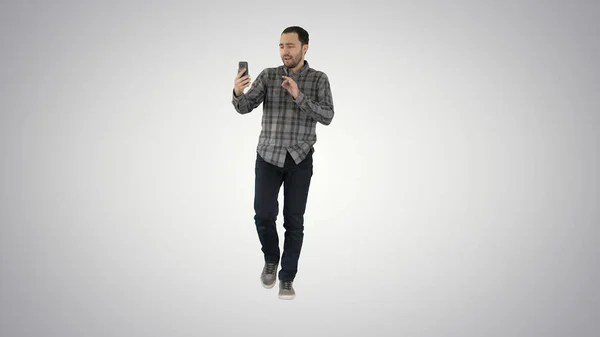 Человек звонит через видео-звонок по телефону, разговаривает с кем-то, кто машет ему — стоковое фото
