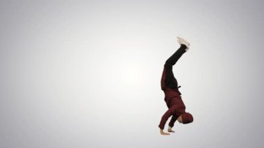 Kırmızı üniformalı bir aşçı, takla atıyor ve el sallıyor. Arkaplanda kameraya bakıyor..