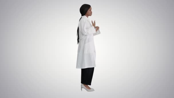 Ung afrikansk amerikansk kvinnlig läkare talar om sjukvård på lutning bakgrund. — Stockvideo