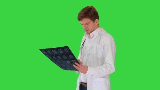 男医生检查电脑断层扫描，并在绿色屏幕上满意地看着相机。. — 图库视频影像