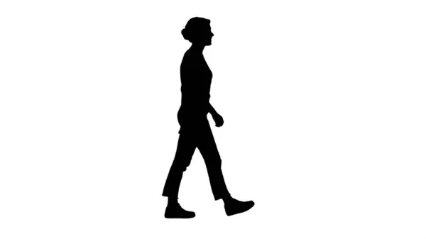 Kırmızı tişörtlü, kot pantolonlu ve spor ayakkabılı kadın yürüyor.. — Stok fotoğraf
