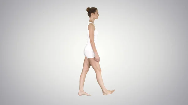 Одна самка ходит босиком в градиентной одежде на градиенте назад — стоковое фото