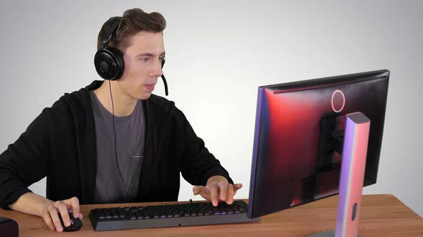 ヘッドフォンでゲーマーの男は、コンピュータ上でビデオゲームをプレイし、勝利 — ストック写真