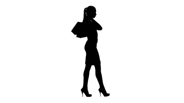 Silhouette Όμορφη χαμογελαστή γυναίκα με επίσημο φόρεμα περπάτημα με — Φωτογραφία Αρχείου