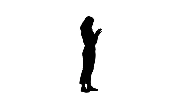 Silhouette donna casual sorridente che tiene lo smartphone usandolo. — Foto Stock