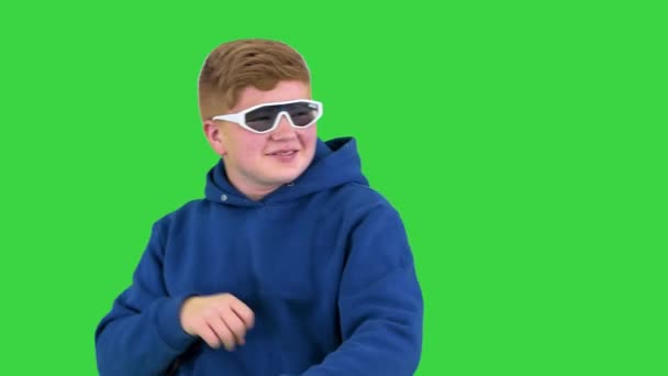 Подросток в солнечных очках делает несколько крутых танцевальных движений на Зеленом экране, Chroma Key. — стоковое видео