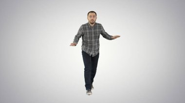 Gayri resmi kıyafetli genç adam gradyan çuvalı üzerinde yürüyor ve dans ediyor.