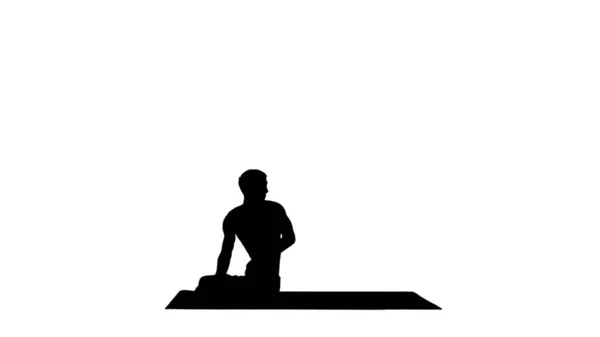 Silhouette Ein junger starker Mann macht Yoga-Übungen und dehnt ein Polster — Stockfoto