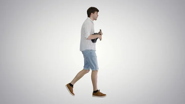 Νεαρός άνδρας παίζει γιουκαλίλι ενώ περπατά σε βαθμιδωτό φόντο. — Φωτογραφία Αρχείου