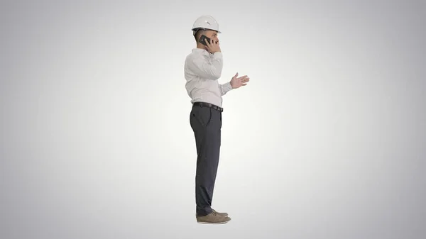 Ingenjör i vit hatt pratar på sin mobiltelefon på gradie — Stockfoto