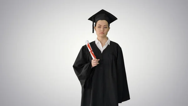 Frustrerad kvinna student i examen mantel skakar hennes diplom — Stockfoto