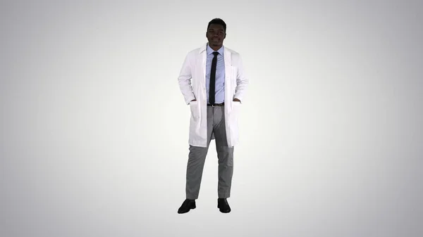 Αρσενικό Αφρικανός γιατρός στέκεται με τα χέρια στην τσέπη του σε γκρι — Φωτογραφία Αρχείου