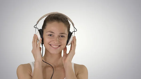 Sorrindo jovem ouvindo música com fones de ouvido no gradie — Fotografia de Stock