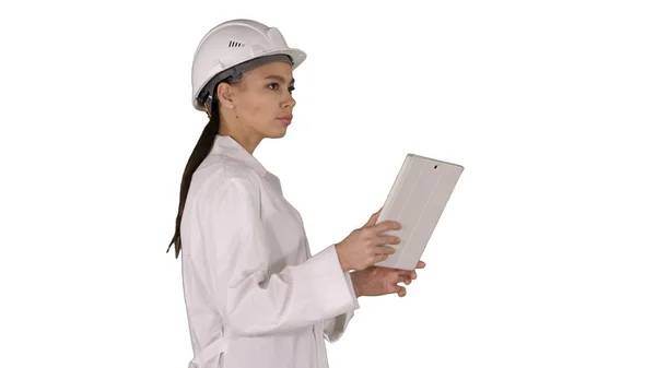 Mladá žena inženýr chůze s tablet při pohledu na objekty arou — Stock fotografie