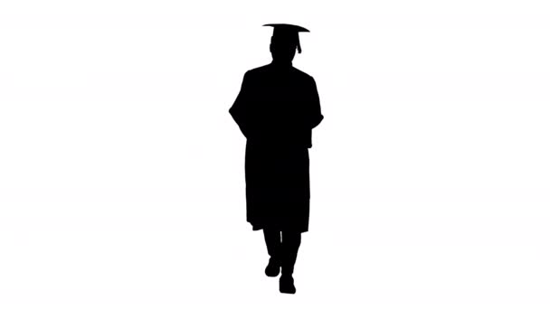 Silhouette African american male student in graduation robe texting on the phone while walking with his diploma.