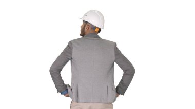 Mühendis beyaz arka planda duruyor ve etrafa bakıyor.