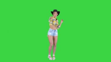 Kovboy şapkalı genç bayan yeşil ekranda dans ediyor, Chroma Key.