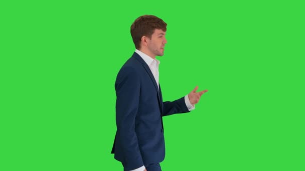 Empresario caminando y explicando algo a la cámara en una pantalla verde, Chroma Key. — Vídeo de stock