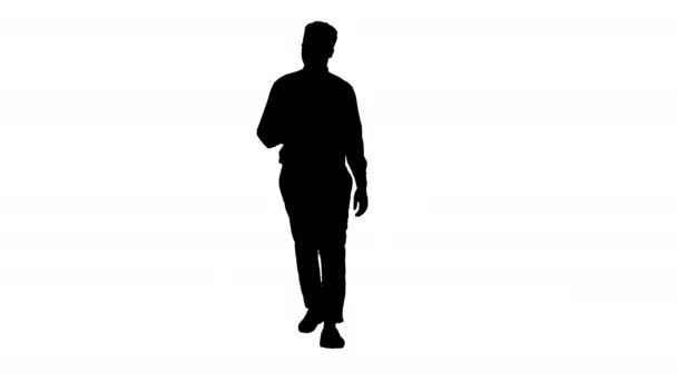シルエットアフリカ系アメリカ人のビジネスマンが歩きながら携帯電話で自撮り. — ストック動画