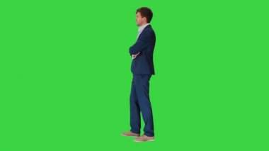 Yakışıklı genç işadamı kollarını kavuşturmuş, yeşil ekranda güvenle gülümsüyor, Chroma Key.